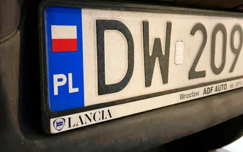 Tablica rejestracyjna z napisem "DW 209" i flagą Polski. Zsd rejestracja Lancia z Wrocławia.
