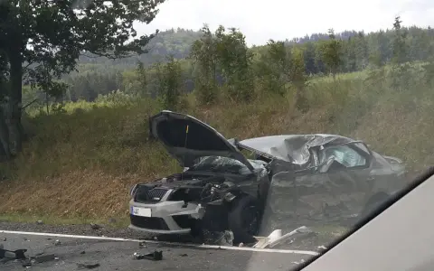 Zniszczony samochód po wypadku, maska otwarta, widoczne uszkodzenia. DKL rejestracja widoczna na przodzie pojazdu.