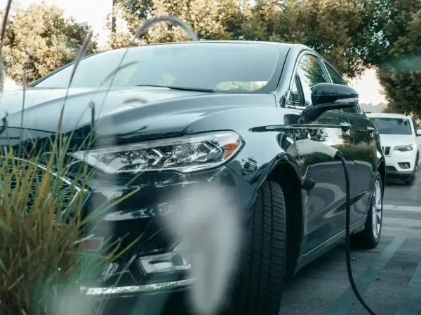 Ciemna toyota hybryda podłączona do ładowarki, gotowa na ekologiczną podróż.